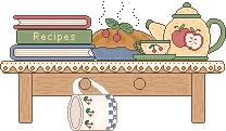 Folk-y looking table with books (one reads 'recipes'), a pie, and a teacup and teapot
